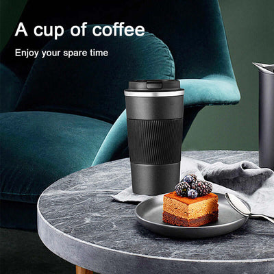 Stylish black insulated travel mug on a marble table with dessert, perfect for enjoying coffee or tea.
