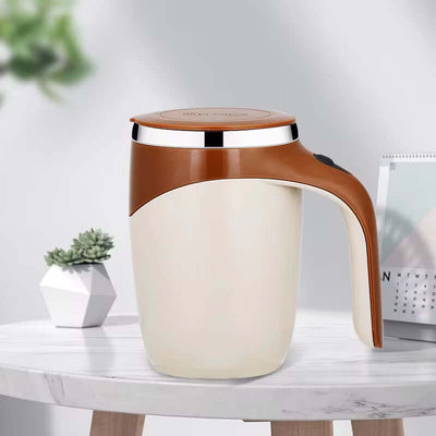 Magnetic self-stirring mug in beige and brown, perfect for home and travel convenience, sitting on a table with greenery.