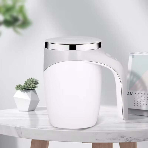 White automatic stirring mug with stainless steel accents on a table, perfect for coffee and tea mixing.